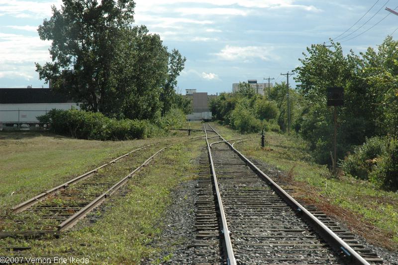 A picture looking west toward the back of the Terrarium shopping centre from Doyan Avenue. This was the location of the run around track used by the local wayfreights at this end of the spur. Notice that the Home Depot is in the background and the trailers that are in photographs below.